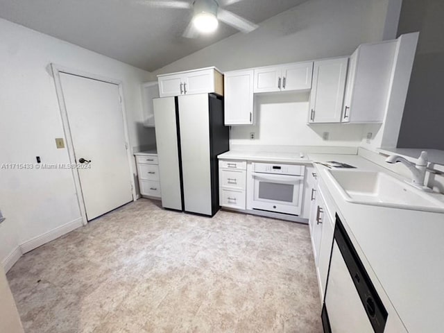 kitchen with lofted ceiling, white appliances, white cabinets, sink, and ceiling fan