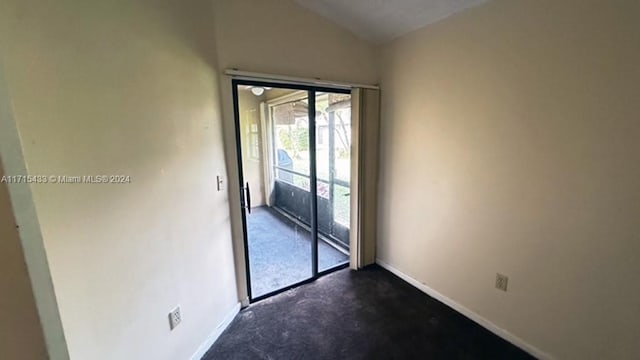 doorway to outside featuring dark carpet and lofted ceiling