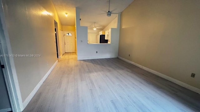 unfurnished room with ceiling fan, lofted ceiling, and light hardwood / wood-style flooring