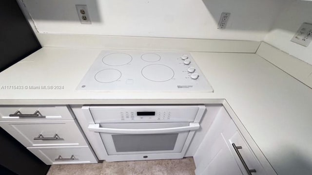 interior details featuring white cabinets and oven