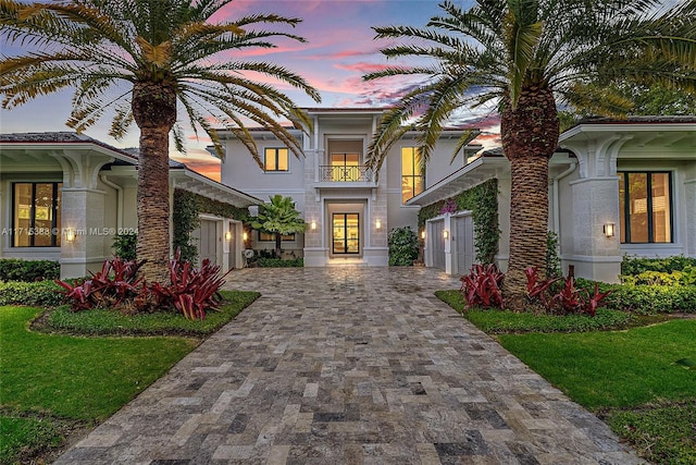 mediterranean / spanish-style house featuring a balcony and a lawn