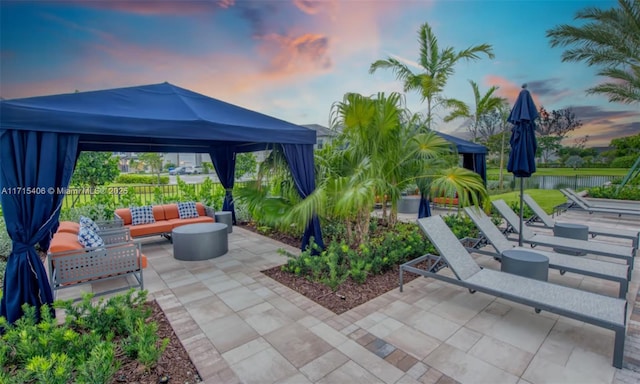 patio terrace at dusk featuring a gazebo and an outdoor hangout area