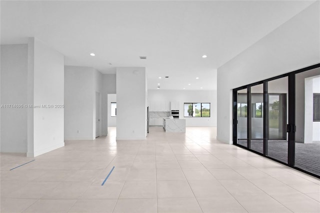 tiled spare room featuring a high ceiling