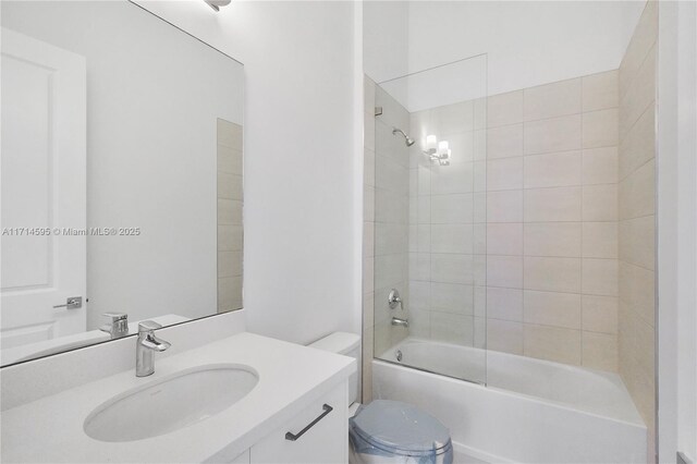 full bathroom featuring tiled shower / bath combo, vanity, and toilet