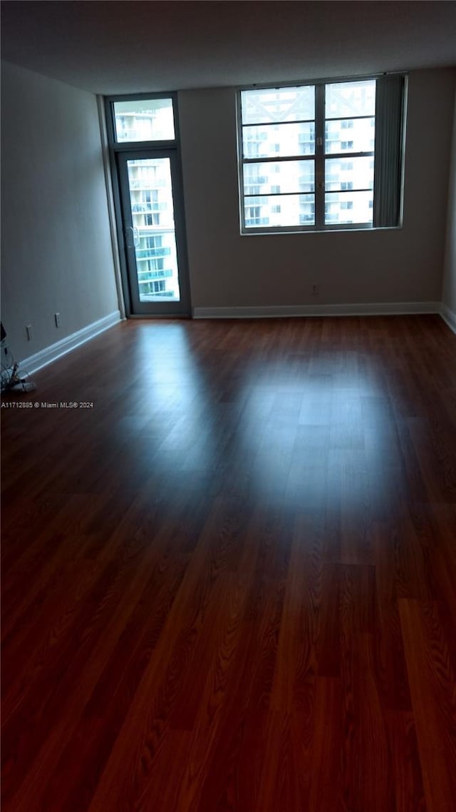 spare room featuring dark hardwood / wood-style floors and plenty of natural light