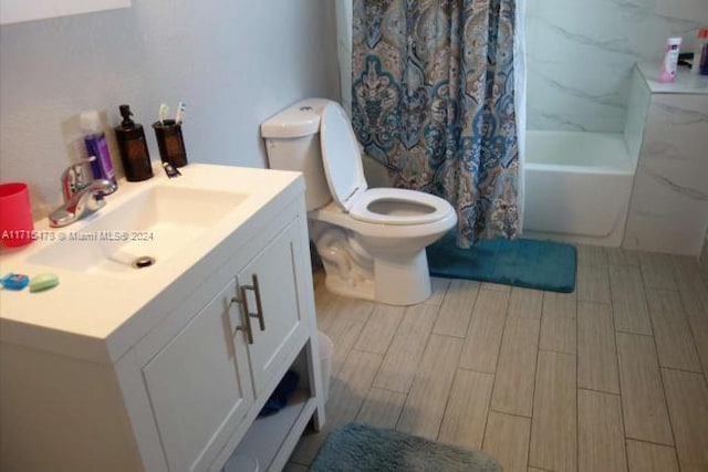 full bathroom with vanity, shower / tub combo, and toilet