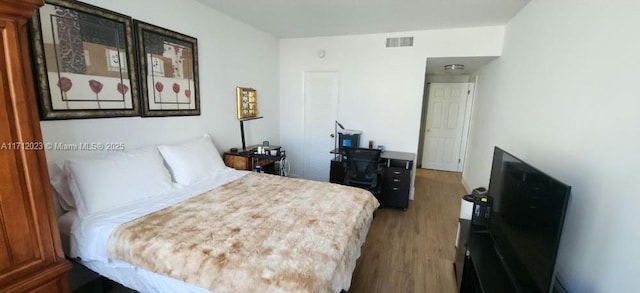 bedroom with wood finished floors and visible vents