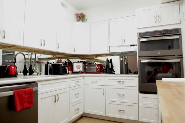 kitchen with appliances with stainless steel finishes and white cabinetry