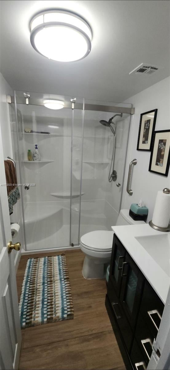 1980 S Ocean Dr Unit 9M, Hallandale Beach, FL 33009 - full bath with a shower stall, wood finished floors, visible vents, toilet, and vanity