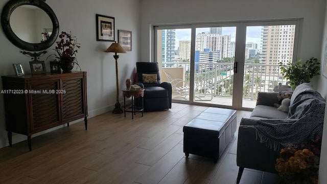 sitting room with a view of city, baseboards, and wood finished floors