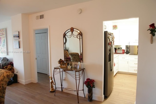 hall with visible vents and light wood finished floors