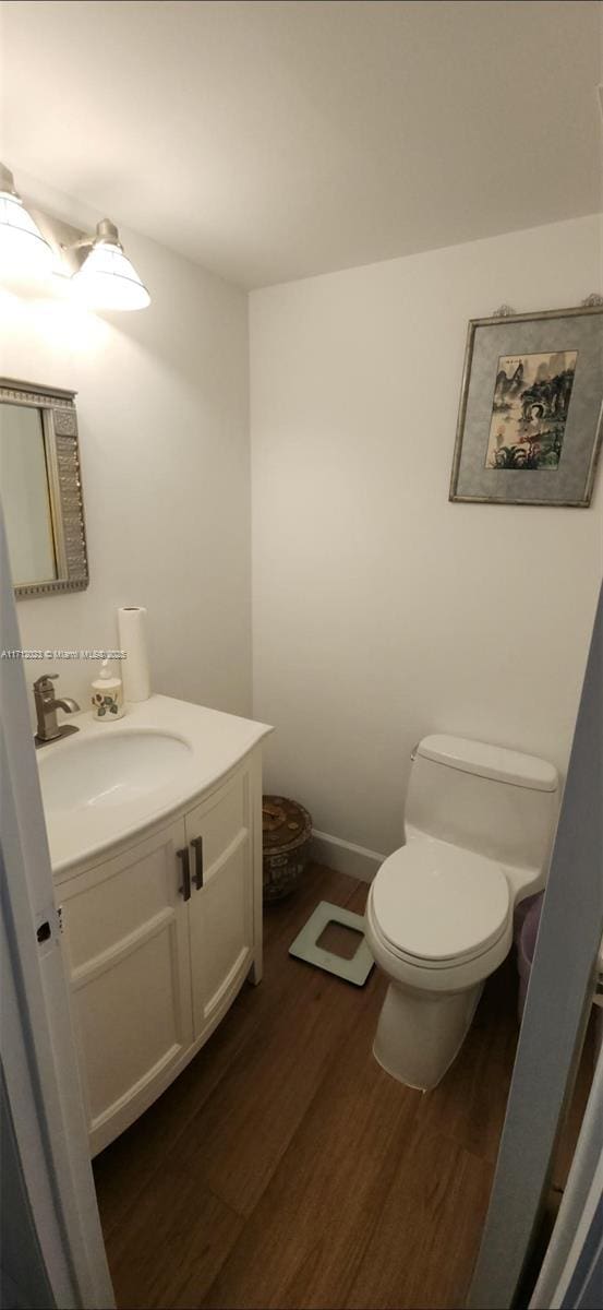 bathroom featuring toilet, wood finished floors, and vanity