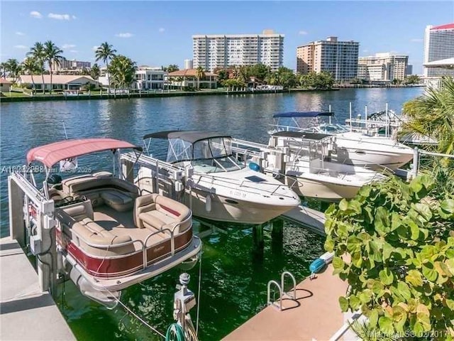 dock area with a view of city, a water view, and boat lift