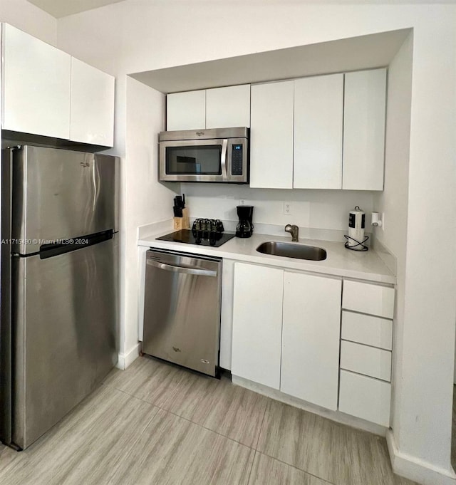 kitchen featuring white cabinets, appliances with stainless steel finishes, and sink