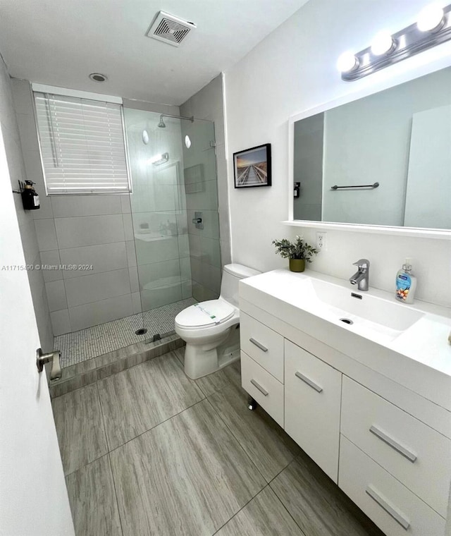 bathroom with vanity, toilet, and a shower with shower door