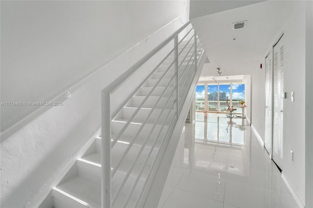 stairs featuring baseboards, tile patterned floors, and visible vents