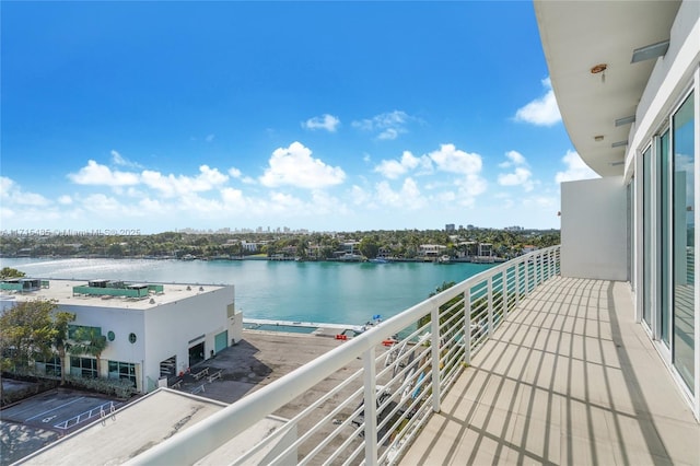 balcony with a water view and a view of city