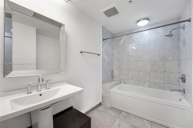 bathroom with a sink, marble finish floor, shower / bath combination, baseboards, and visible vents