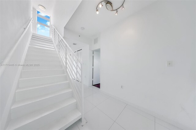 staircase featuring tile patterned floors and visible vents