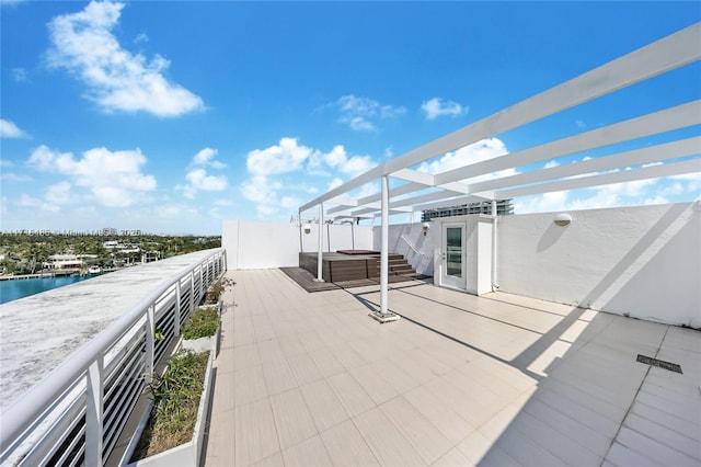 view of patio featuring a pergola, a hot tub, and a water view