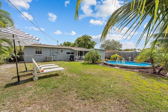 view of yard with a fenced in pool, central AC, and a sunroom