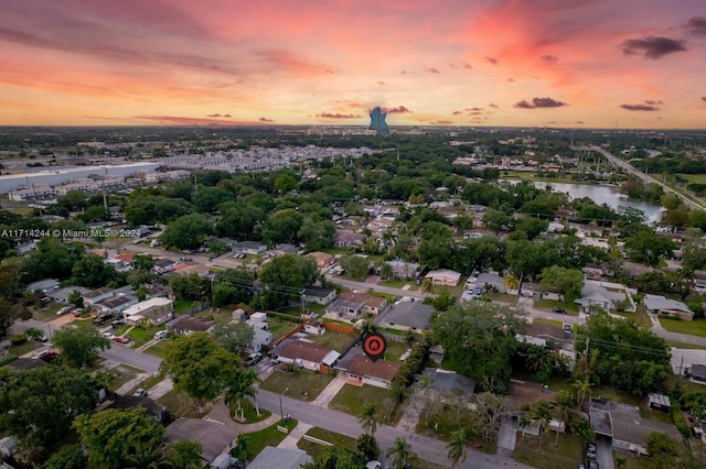 aerial view at dusk featuring a water view