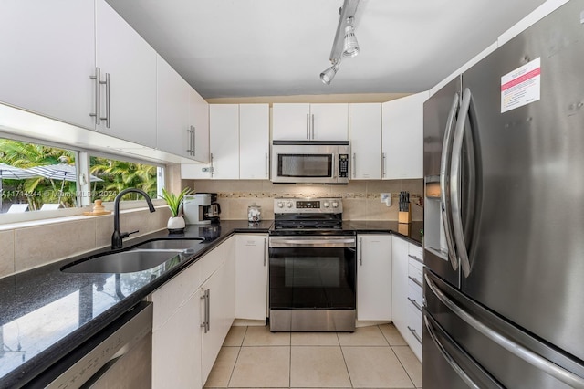 kitchen with sink, white cabinetry, stainless steel appliances, and light tile patterned floors