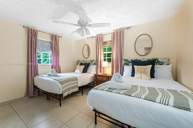 bedroom featuring light tile patterned floors, a textured ceiling, and ceiling fan