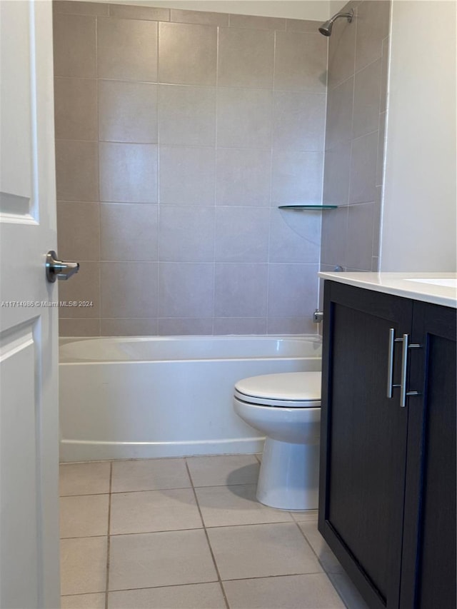 full bathroom featuring tiled shower / bath, tile patterned flooring, vanity, and toilet