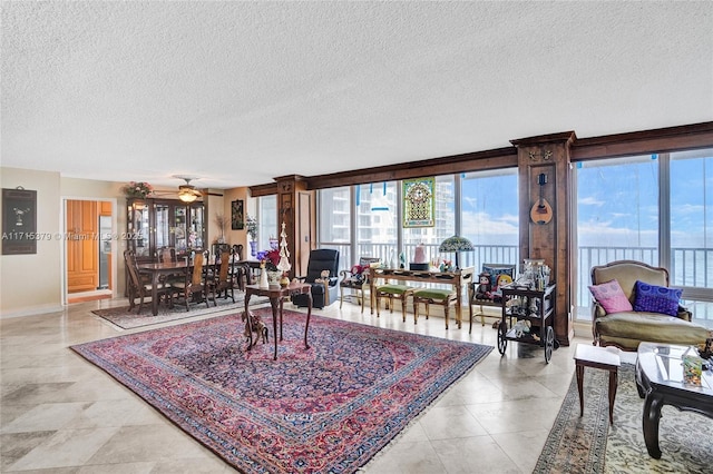 living room with ceiling fan and a textured ceiling