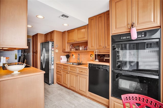 kitchen with black appliances, light tile patterned floors, and sink