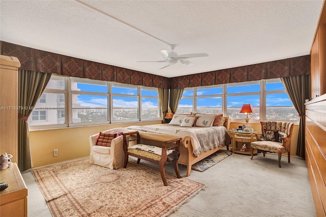 carpeted bedroom featuring multiple windows, ceiling fan, and a textured ceiling