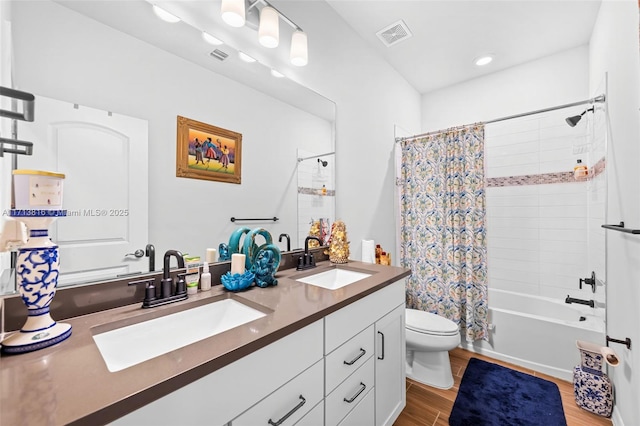 full bathroom featuring vanity, hardwood / wood-style floors, shower / tub combo, and toilet