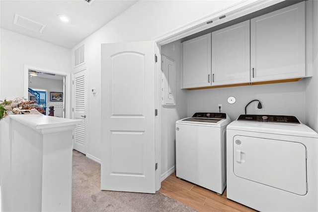 washroom with cabinets, washing machine and dryer, and light wood-type flooring