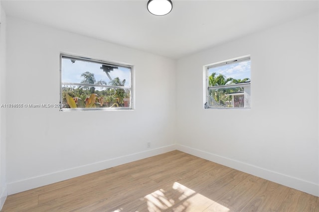 spare room featuring plenty of natural light and light hardwood / wood-style flooring