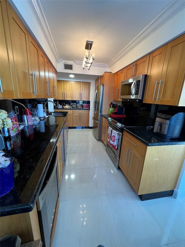 kitchen featuring sink, an inviting chandelier, dark stone countertops, decorative light fixtures, and appliances with stainless steel finishes