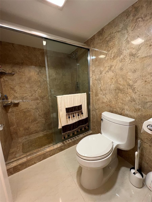 bathroom featuring tile patterned flooring, toilet, and walk in shower