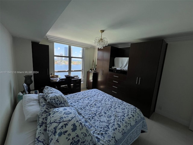 bedroom featuring a water view and an inviting chandelier