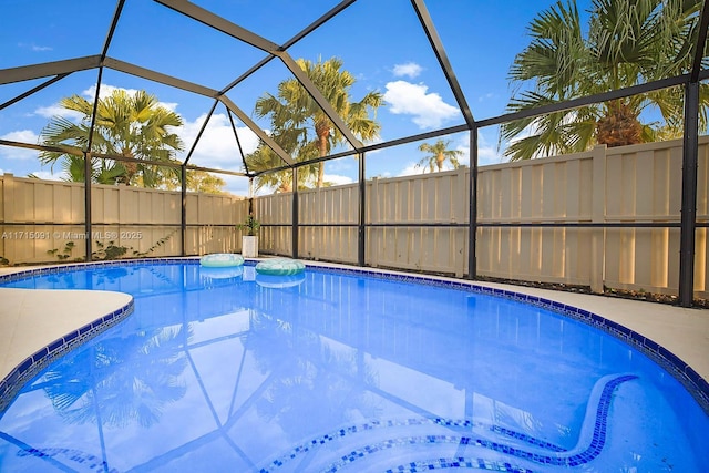 view of swimming pool featuring glass enclosure