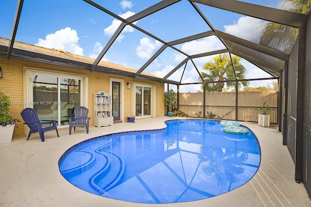 view of swimming pool with a patio and glass enclosure