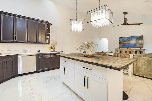 kitchen with wood counters, white cabinets, stainless steel dishwasher, ceiling fan, and decorative light fixtures