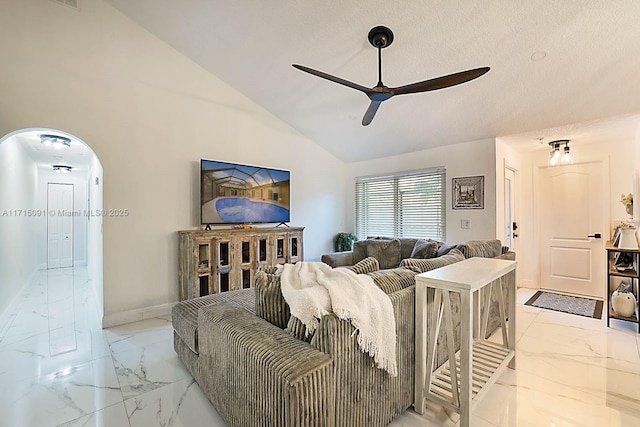 living room with ceiling fan, lofted ceiling, and a textured ceiling