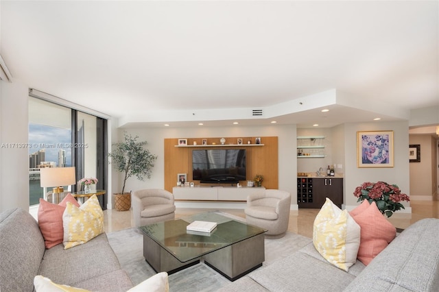 living room with a healthy amount of sunlight, bar area, and a wall of windows