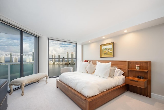 bedroom with access to outside, light colored carpet, and expansive windows