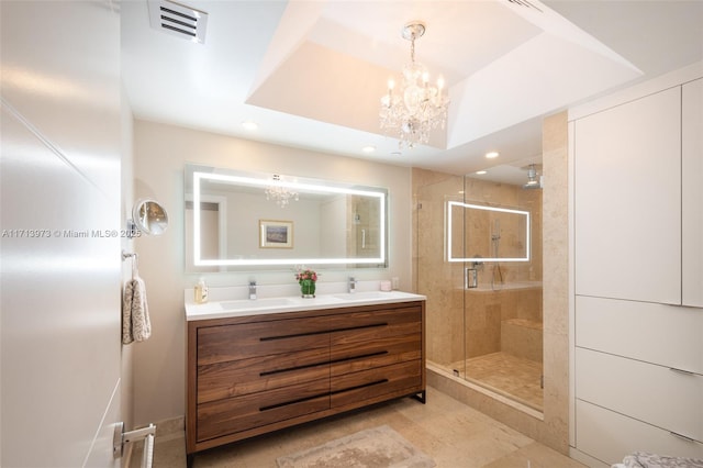 bathroom featuring vanity, a shower with door, and a chandelier