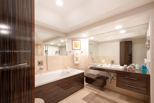 bathroom featuring tile patterned flooring, sink, and a tub to relax in