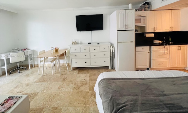 interior space featuring white fridge, ornamental molding, and sink