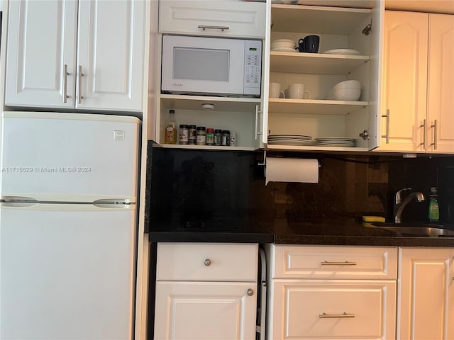 kitchen featuring white cabinetry, white appliances, sink, and tasteful backsplash