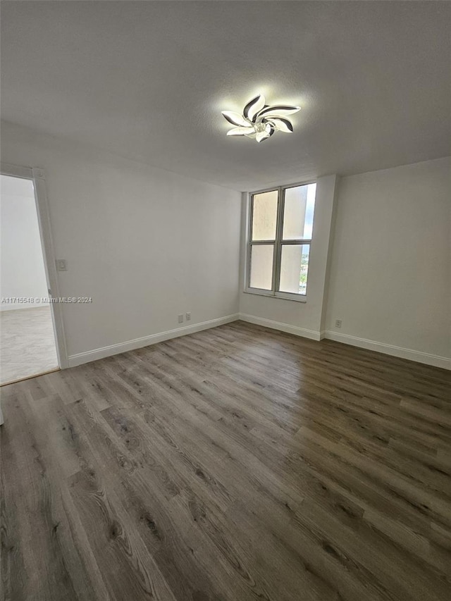 spare room featuring dark hardwood / wood-style flooring and a textured ceiling