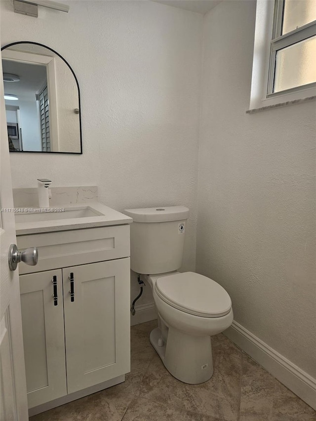 bathroom with tile patterned flooring, vanity, and toilet